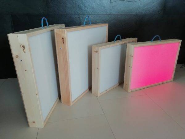 quatre tables lumineuses dont une allumée diffusant une lumière rose